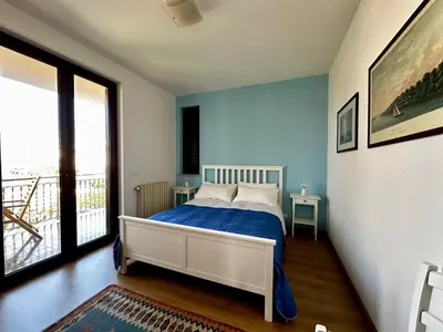 a bedroom with a bed and a large window at Garden House Alla Torre in Isola delle Femmine