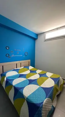 a bedroom with a bed and a blue wall at Maresol in Trappeto