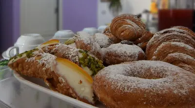 a tray of donuts and pastries on a table at B&B Alighieri 21 in San Vito lo Capo