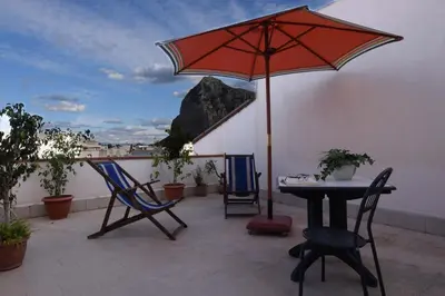 a patio with a table and chairs and an umbrella at B&B Alighieri 21 in San Vito lo Capo