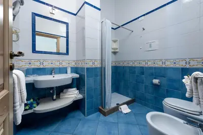 a bathroom with a sink toilet and a shower at Albert Rooms & Breakfast in San Vito lo Capo