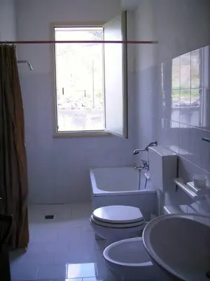 a bathroom with a toilet and a tub and a window at Villetta San Giovanni in Calatafimi