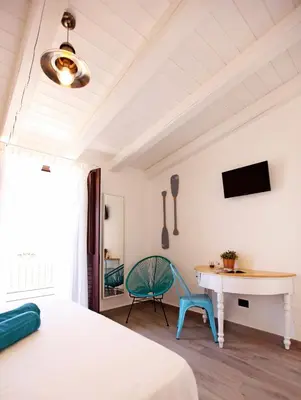 a bedroom with a bed and a desk and a chair at Via Siracusa 5 in Castellammare del Golfo