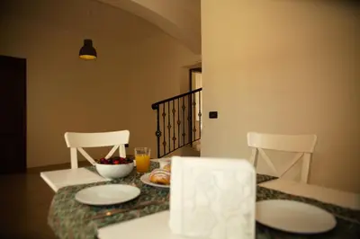 a dining room table with two chairs and plates of food at BnB DonnaLaura in Carini