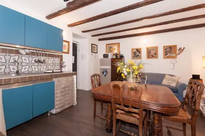 a kitchen and dining room with a wooden table and blue cabinets at Casetta Nostra in Palermo