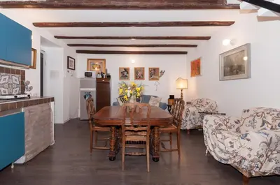 a kitchen and living room with a wooden table and chairs at Casetta Nostra in Palermo