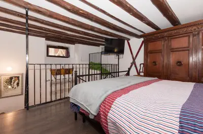 a bedroom with a bed and a tv on the wall at Casetta Nostra in Palermo