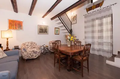 a living room with a wooden table and chairs at Casetta Nostra in Palermo