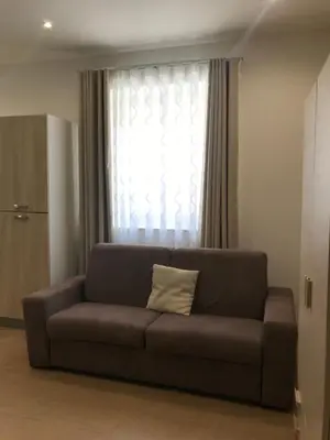 a brown couch with a pillow in front of a window at Le Quattro Perle in Terrasini