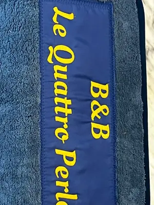 a blue blanket with yellow writing on it at Le Quattro Perle in Terrasini
