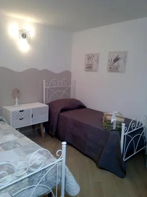 a bedroom with two beds and a nightstand and a bed sidx sidx sidx sidx at Casa Vacanze TAMARA in Balestrate