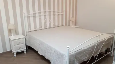 a bedroom with a white bed and two night stands at Casa Vacanze TAMARA in Balestrate
