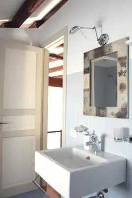 a bathroom with a white sink and a mirror at Speciale Apartment in Palermo