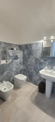 a bathroom with two sinks and a toilet and a bidet at A un passo dal Massimo in Palermo
