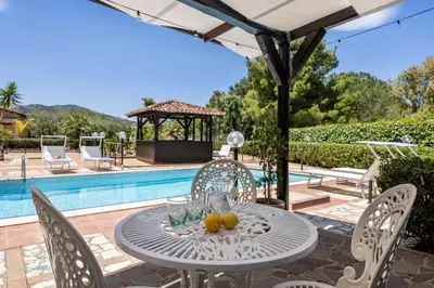 a table with fruit on it next to a pool at Villa Cocos in Casteldaccia