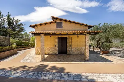 a small yellow building with a door at Villa Cocos in Casteldaccia
