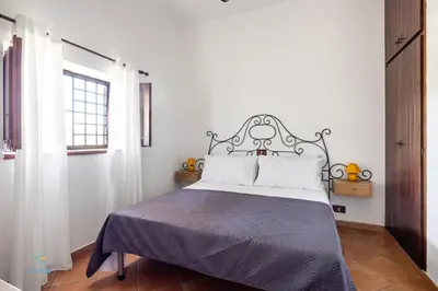 a bedroom with a bed with a black and white headboard at Villa Cocos in Casteldaccia
