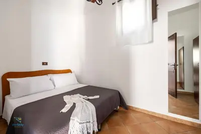 a bedroom with a bed with a blanket on it at Villa Cocos in Casteldaccia