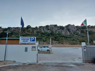 a car parked in a parking lot with two flags at Catalina in San Vito lo Capo