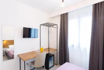 a room with a table and a mirror and a bed at Catalina in San Vito lo Capo