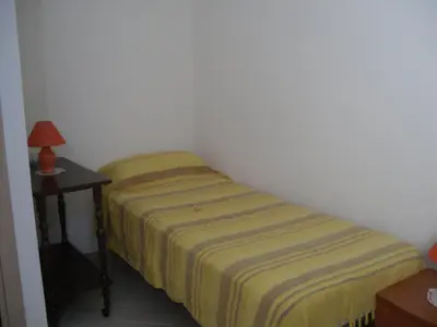 a small bedroom with a bed and a night stand at Vicino al mare e lontano dai rumori in Alcamo Marina