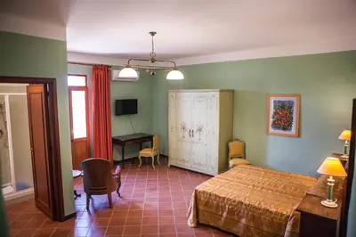 a bedroom with a bed and a desk in it at Palazzo Q-tò in Monreale