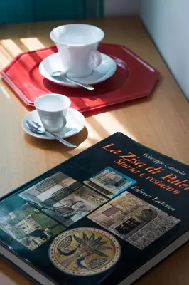 a book sitting on top of a table with two cups at My Way - Suite - Rooms - Palazzo San Matteo in Palermo