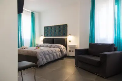 a bedroom with a bed and a chair at My Way - Suite - Rooms - Palazzo San Matteo in Palermo