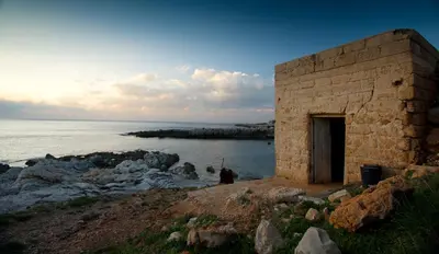 a brick building on the shore of the ocean at Un mare di Blu - Casa Cobalto in Macari