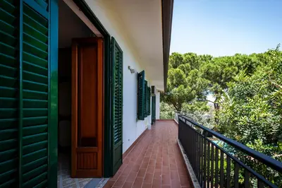 a balcony with a green door and a brick walkway at Casa del carrubo in Carini