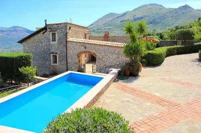 a villa with a swimming pool in front of a house at Casale Maddalena in Carini