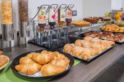 a buffet filled with different types of bread and pastries at Camplus Palermo Normanni - in Palermo