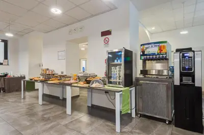 a kitchen with a table with food and a refrigerator at Camplus Palermo Normanni - in Palermo