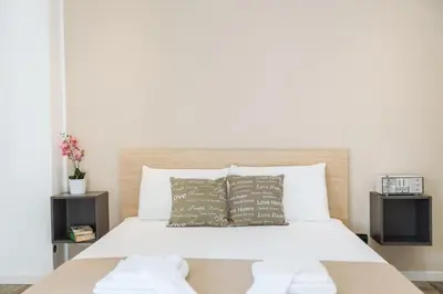 a bedroom with a white bed with two pillows at Politeama Luxury Suites in Palermo
