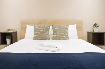 a bedroom with a white bed with two pillows at Politeama Luxury Suites in Palermo