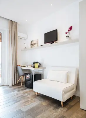 a living room with a white couch and a desk at Politeama Luxury Suites in Palermo