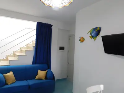 a blue couch in a living room with a staircase at Residenza del Mare & SPA in San Vito lo Capo