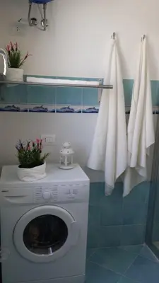 a laundry room with a washing machine and towels at Residenza del Mare & SPA in San Vito lo Capo