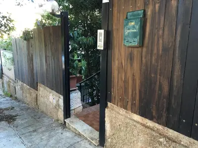 a wooden fence with a gate with a sign on it at House in Mondello in Mondello