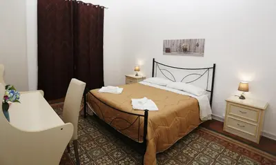 a bedroom with a bed and a table and a chair at Rest and Go in Palermo