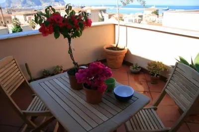 a wooden table with flowers on a balcony at Panoramica Blu in Palermo
