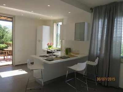 a kitchen with a island with a sink and chairs at casa verdemare in Cefalù