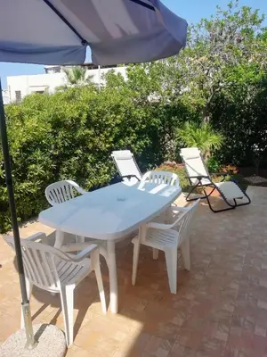 a table and chairs with an umbrella on a patio at Appartamento con Giardino - WIFI in San Vito lo Capo