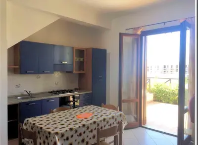 a kitchen with a table with a table cloth on it at Appartamento con Giardino - WIFI in San Vito lo Capo