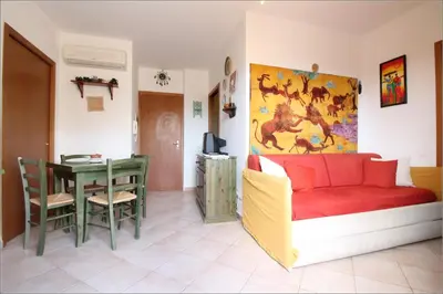 a living room with a red couch and a table at Senia in San Vito lo Capo