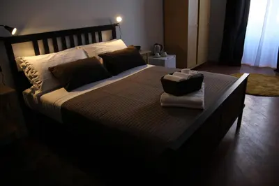 a bedroom with a large bed with a wooden headboard at B&B Gallidoro in Palermo