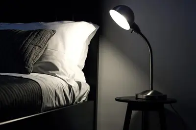 a lamp sitting on a table next to a bed at B&B Gallidoro in Palermo