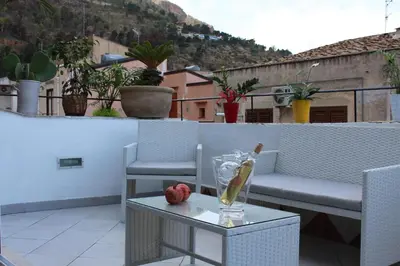 a balcony with a couch and a table with apples on it at Terrazza in Palazzo Taormina in Castellammare del Golfo