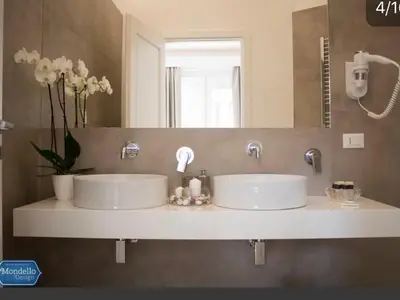 two white sinks in a bathroom with a mirror at B&B Mondello Design in Mondello