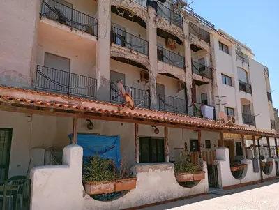 an apartment building with potted plants on the balcony at Bilocale Lungomare Carini in Carini